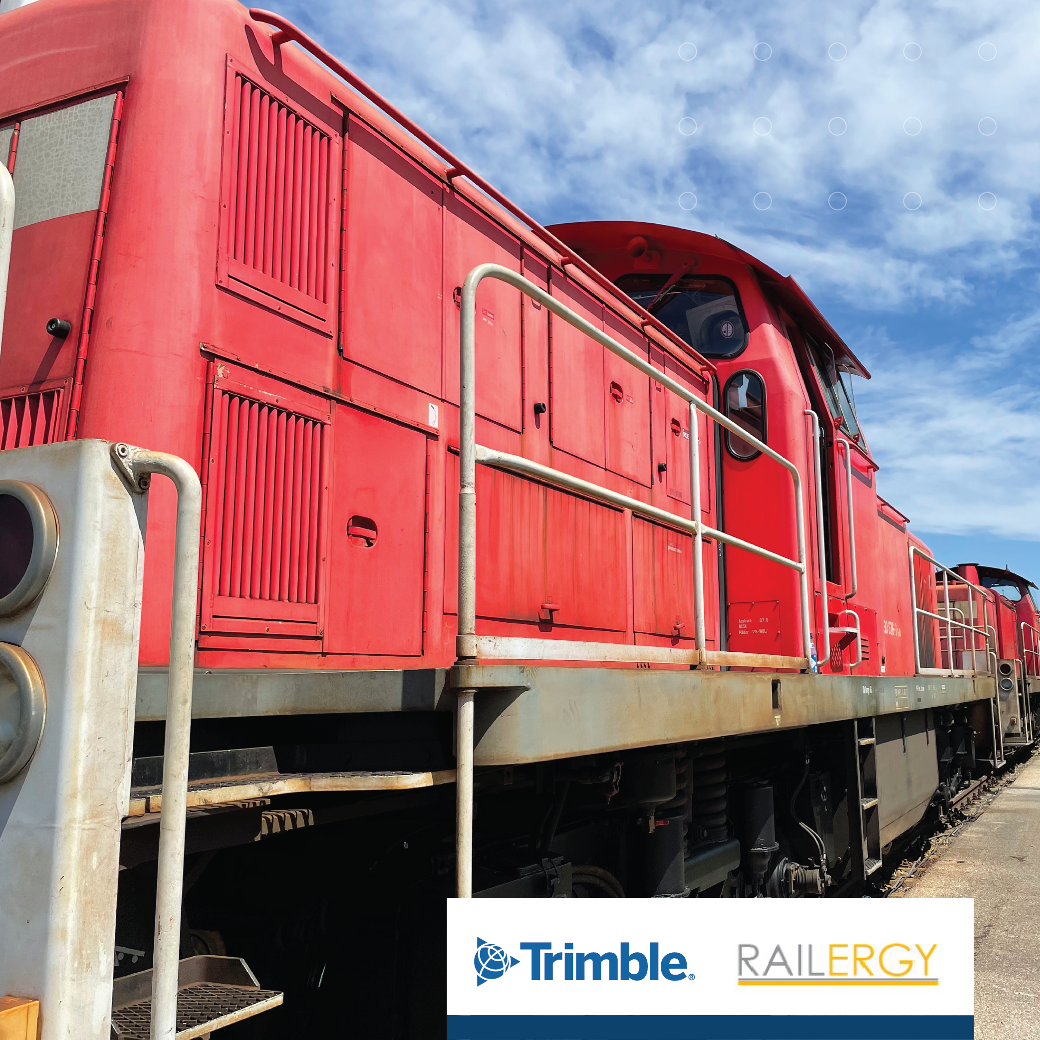 Picture of a red VAL train with the Trimble and Railergy logos in the top banner