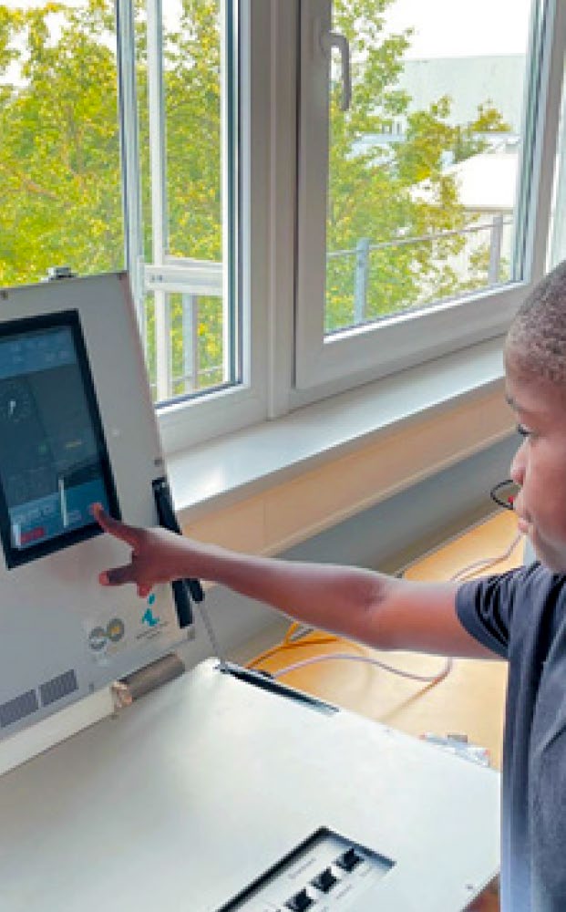 Image of a boy pointing to a computer screen where Railergy software is visible.